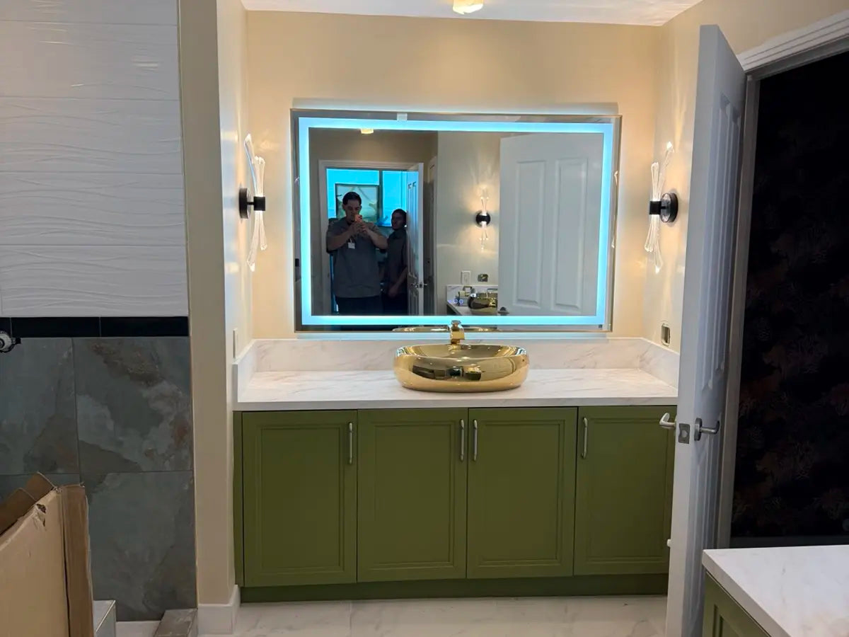 Bathroom renovation with illuminated mirror and green vanity